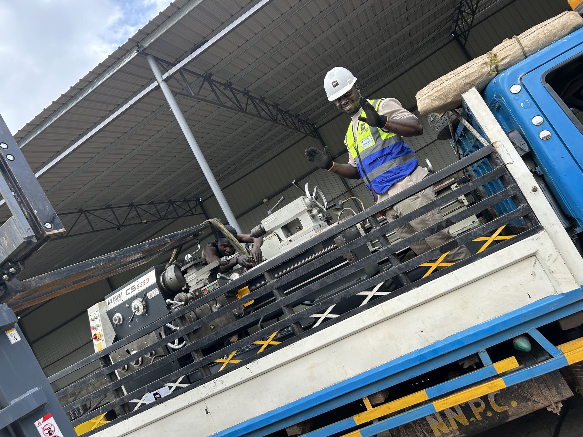 TME Africa team member on the delivery truck with a lathe machine