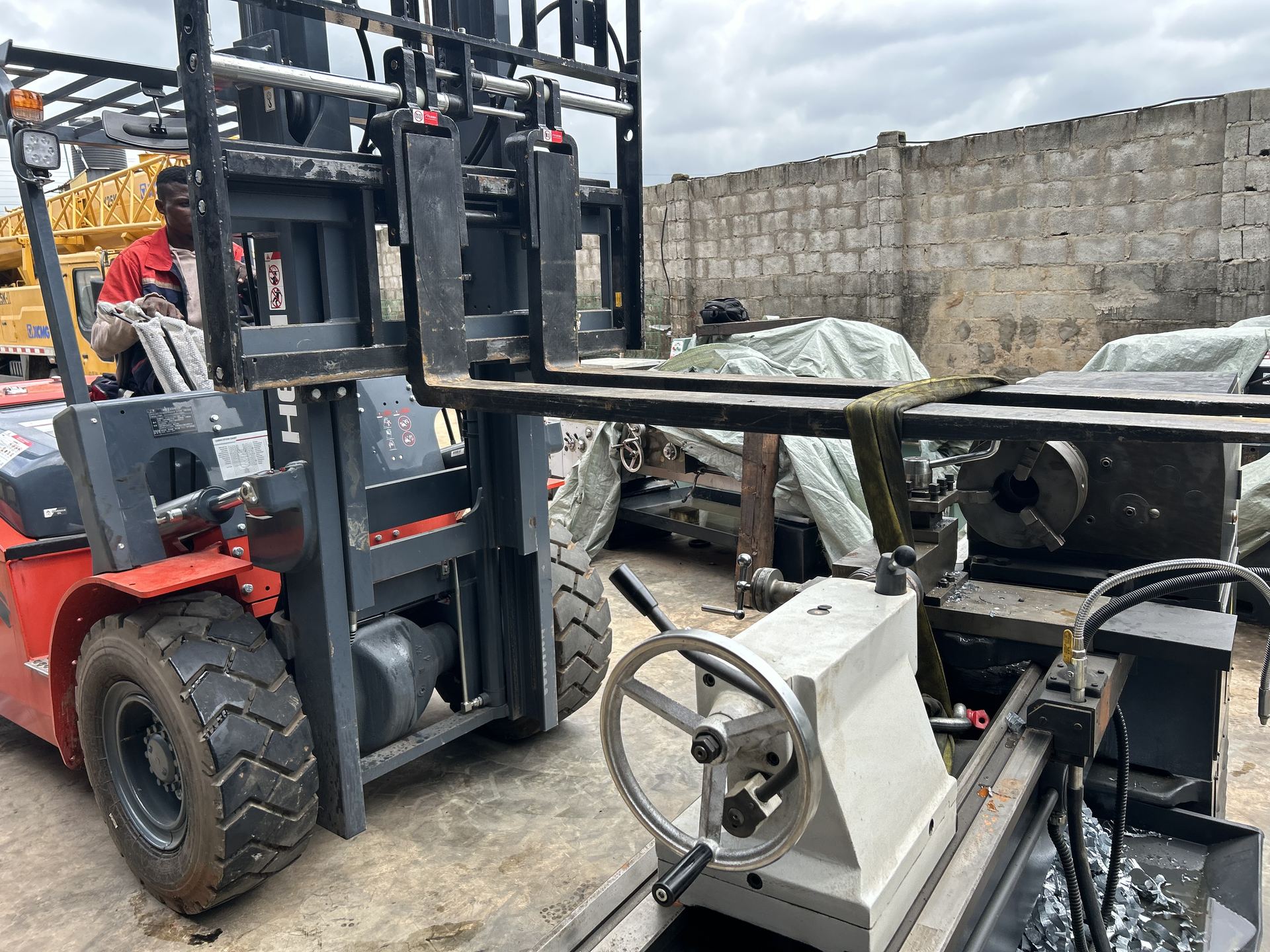 Forklift loading machinery onto the client delivery truck
